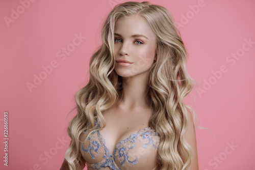 Fotografia blonde girl posing in lingerie on pink background
