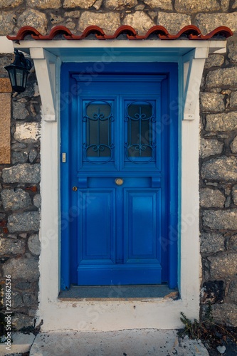 Scenic shot of a picturesque door entrance into a stone house  painted in the greek colours on Samothrace Island in the city of Samothraki © ionutpetrea