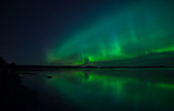 Northern lights dancing over calm lake in Farnebofjarden national park in Sweden