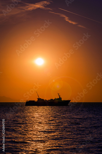 Large ferry boat at sunset on the Aegean Sea leaving Samothrace Island in Greece at sunset