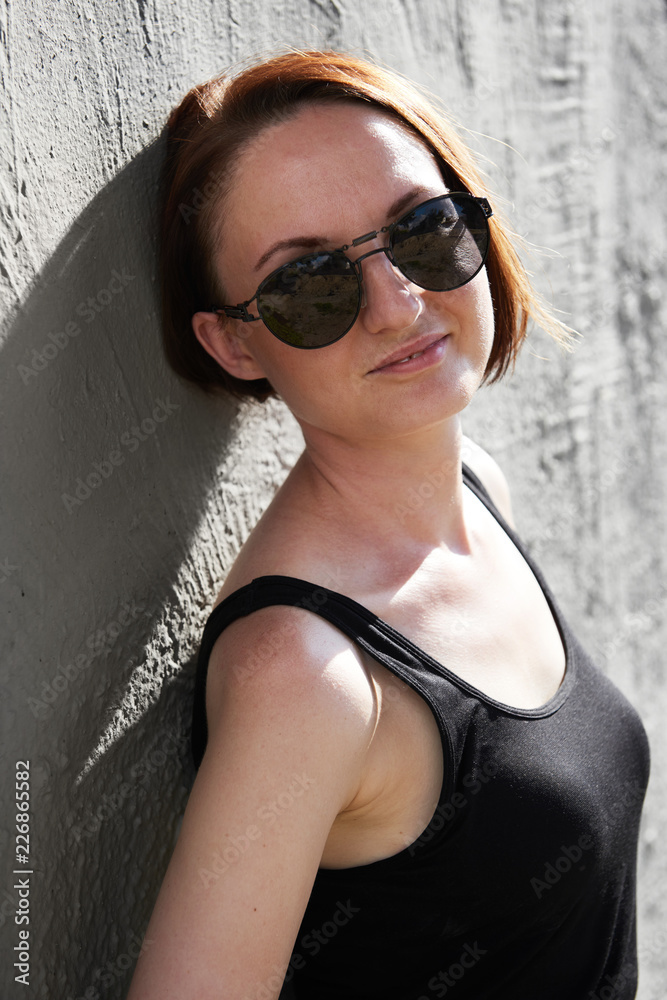 young girl posing against a concrete wall, dressed in black, hard light and shadows young girl posing against a concrete wall, dressed in black, hard light and shadows