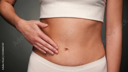 Attractive woman with naked stomach rubbing her belly