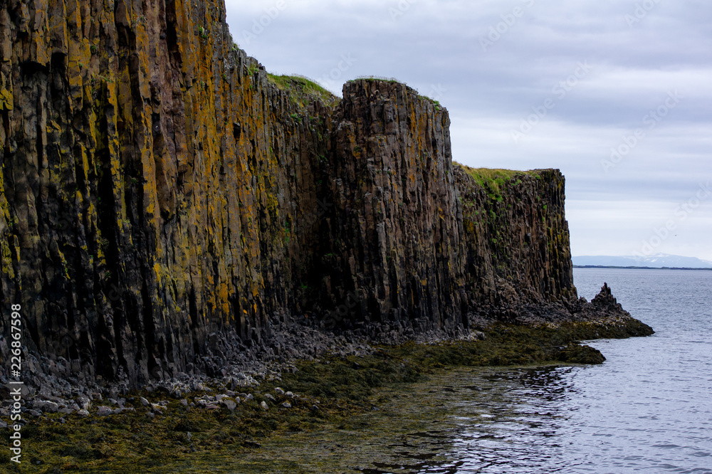 Basalt rocks reflected in an ocean near the city Stykkishólmur in Iceland
