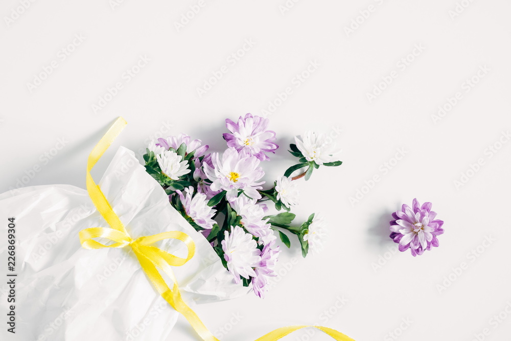 Flowers composition. Pattern made of purple flowers in a white paper bag on white background. Flat lay, top view, copy space Flowers composition. Pattern made of purple flowers in a white paper bag on white background. Flat lay, top view, copy space