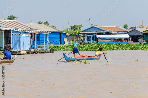 Wallpaper Mural  Floating village on the Tonle Sap Lake in Cambodia and kids rowing home with their wooden boat Torontodigital.ca
