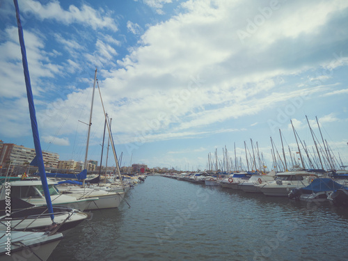 Luxury yacht marina. Port in Mediterranean sea. Sailing boats with a deflated sails near the sea pier.