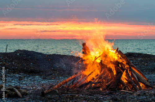Camp fire by the sea at sunset time.