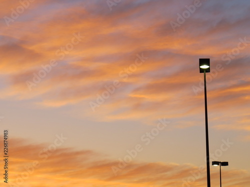 ABSTRACT PHOTO OF ILLUMINATED STREET LIGHTS WITH GOLD YELLOW BLUE AND PINK COLORS IN BACKGROUND SUNSET 