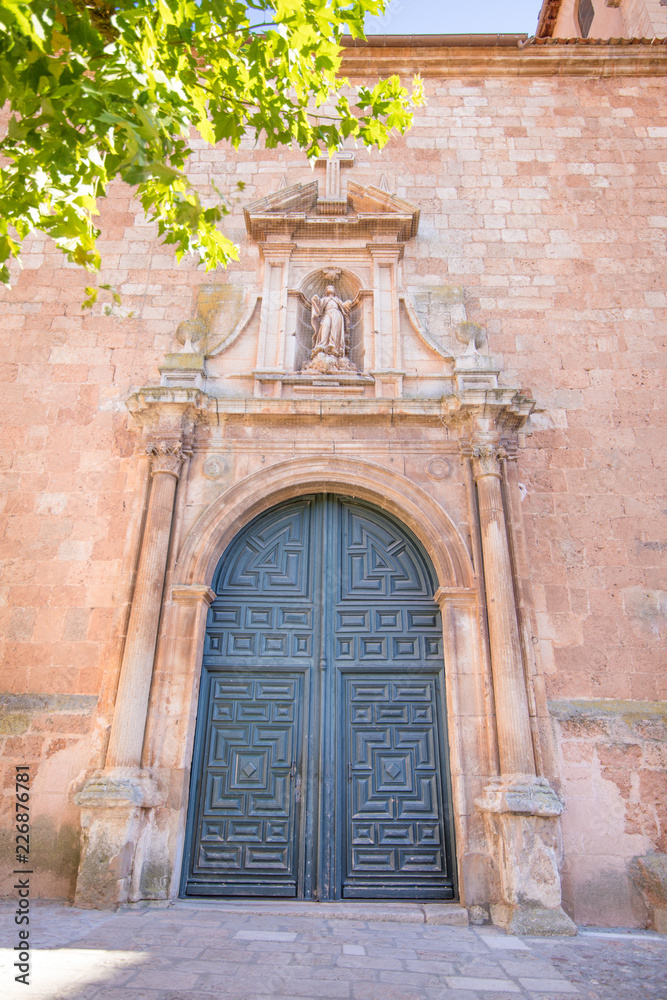 Exterior facade with door, columns and statue, in church Santa Maria La Mayor, neoclassical landmark and public monument from eighteen century, in Ayllon, Segovia, Spain, Europe