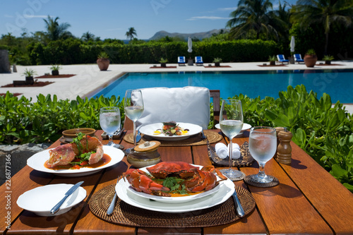 gourmet luxury seafood lunch cuisine in five star tropical resort panorama, crab, tuna, snapper, wine, pool