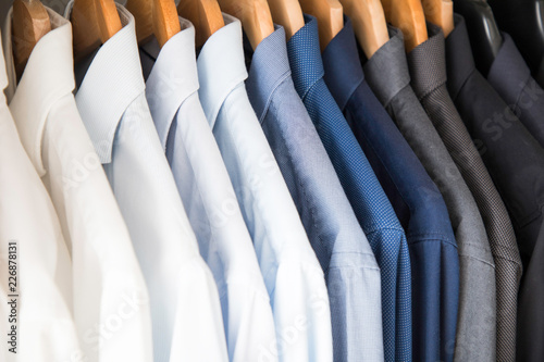 Office Business shirts hanging in a closet ordered by colour photo