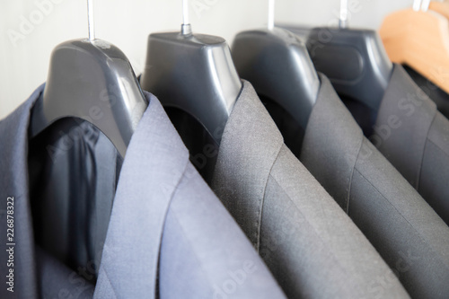 Office Business suits hanging in a closet ordered by colour