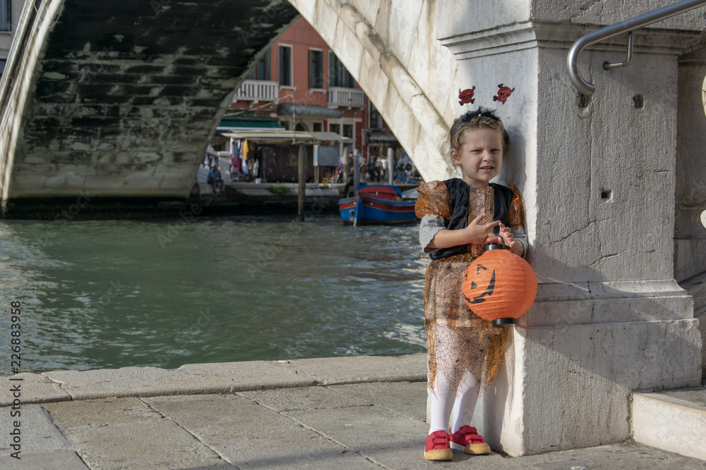 Obraz premium Little girl dressed up for Halloween, posing at the bridge of Scalzi Venice Italy 