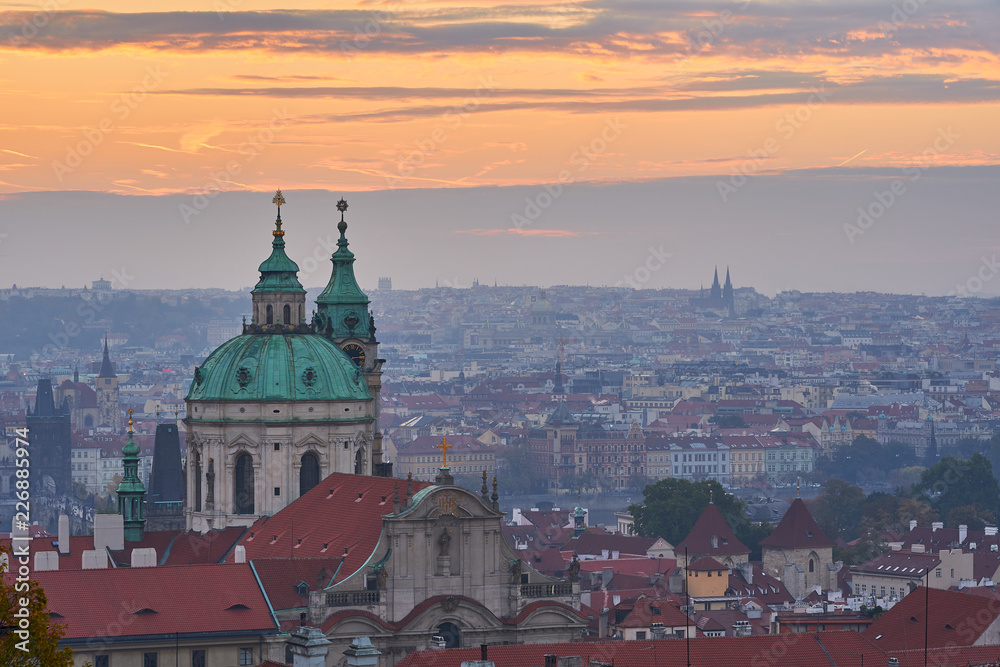Cityscape of landscape Picture of the lesser town with dome of Saint Nicolas church in the Prague, in the morning just before sunrise in blue mood with orange sky. Cityscape of landscape Picture of the lesser town with dome of Saint Nicolas church in the Prague, in the morning just before sunrise in blue mood with orange sky.