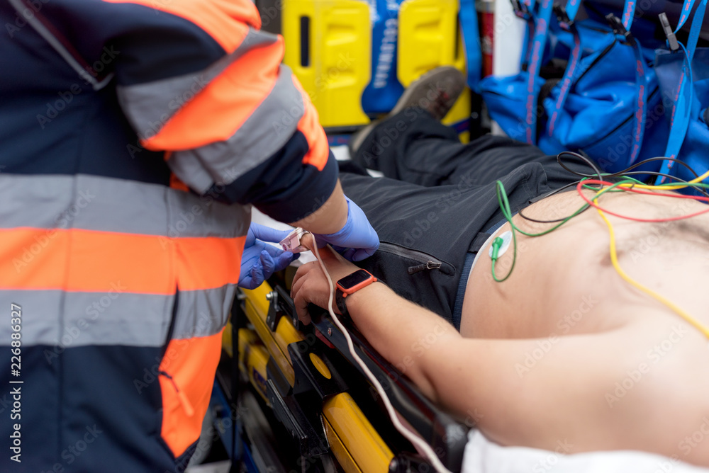 Emergency doctor checking pulse of a patient in the ambulance Emergency doctor checking pulse of a patient in the ambulance