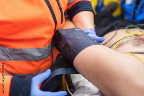 Emergency doctor checking blood pressure of a patient in the ambulance