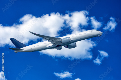 Aeroplane in blue cloudy sky.