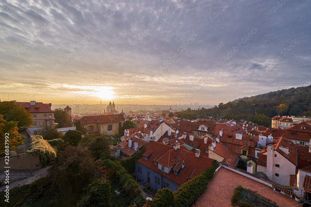 Landcape or cityscape view on old town of Prague and Lesser town during the golden hour in sunrise with beautiful clouds and sun light taken from hill of prague castle.