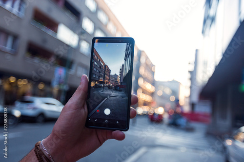 Man taking a picture in the street with his smartphone