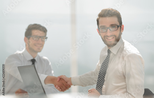 smiling businessman shaking hands with his partner