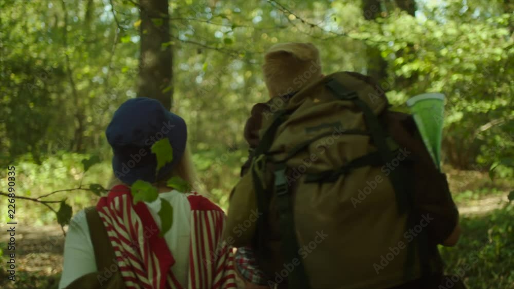Young couple hugging during hiking in the forest with backpacks Young couple hugging during hiking in the forest with backpacks