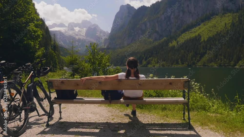Gosausee Austria, young woman sits on bench mountain landscape Gosausee Austria, young woman sits on bench mountain landscape