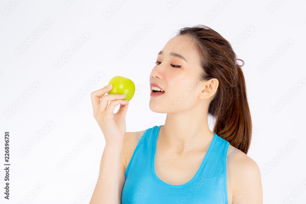 Beautiful portrait young asian woman in sport clothing holding and eating green apple fruit isolated on white background, girl asia have shape and wellness, exercise for fit with health concept. Beautiful portrait young asian woman in sport clothing holding and eating green apple fruit isolated on white background, girl asia have shape and wellness, exercise for fit with health concept.