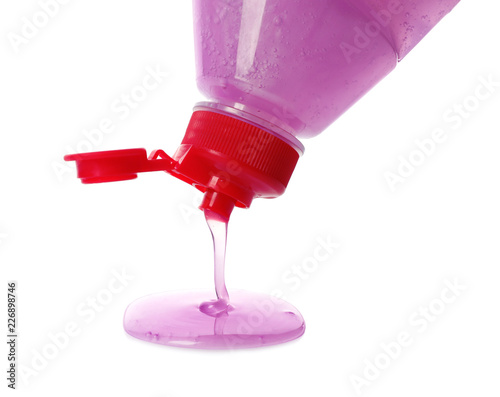 Pouring cleaning product for dish washing on white background, closeup