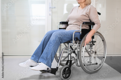 Mature woman sitting in wheelchair indoors