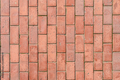 Red paving with imprinted texture of beaten time, with a lot of chips and scratches only on top