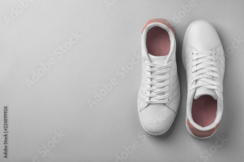 Pair of trendy sneakers on light background, flat lay. Space for text
