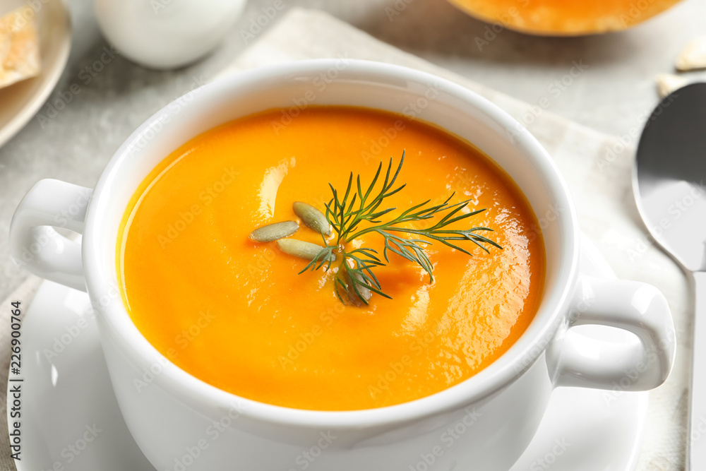 Delicious pumpkin cream soup in bowl on table, closeup Delicious pumpkin cream soup in bowl on table, closeup