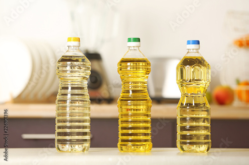 Fototapeta Naklejka Na Ścianę i Meble -  Bottles of oil on table against blurred background