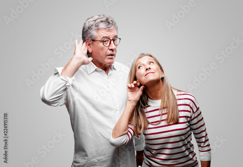 Quadro su tela senior cool husband and wife paying attention, trying to hear and listen to what is being said, lending an ear
