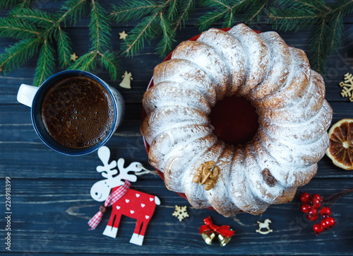 Traditional fruitcake for Christmas decorated with powdered sugar and nuts, raisins. Delicioius Homemade Pastry. New year and Christmas celebration concept photo