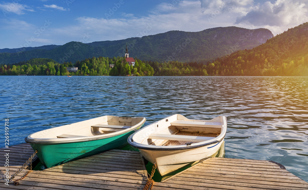 Iconic Bled scenery. Boats at lake Bled, Slovenia, Europe. Wooden boats with Pilgrimage Church of the Assumption of Maria on the Island on Lake Bled, Slovenia