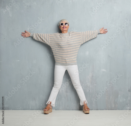 senior cool woman against grunge cement wall.