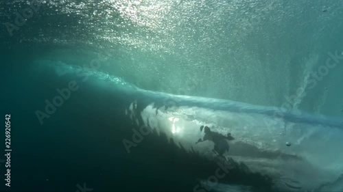 View of surfer catching wave from underwater, slow motion