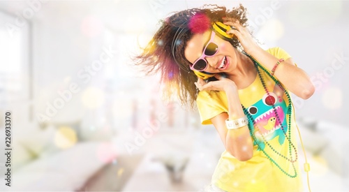Happy young woman listening music in headphones