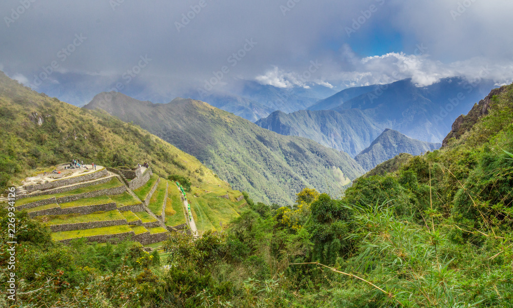 Blue cloudy sky above green terraced mountainside on the Inca Trail in Peru