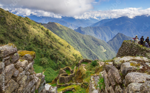 Blue cloudy sky above verdant green mountains and ruins on the Inca Trail in Per Fototapet