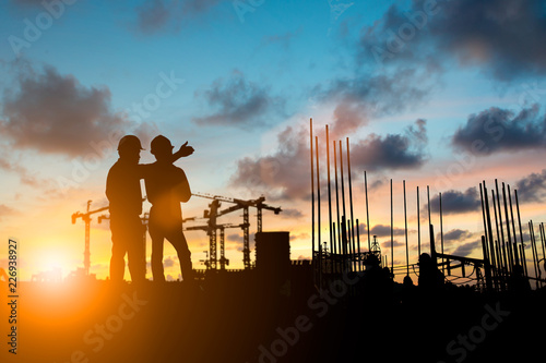 Silhouette of engineer and construction team working at site over blurred background for industry background with Light fair.Create from multiple reference images together