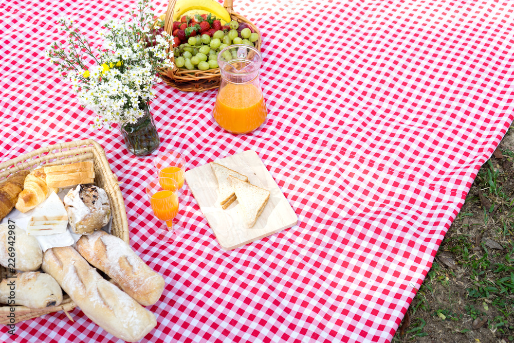 picnic bread crossiant basket with fruit on  red white cloth