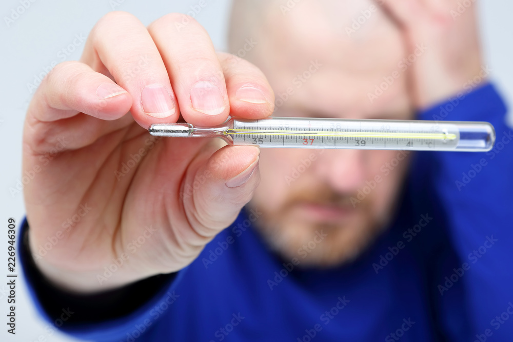 man shows a thermometer with a high temperature man shows a thermometer with a high temperature
