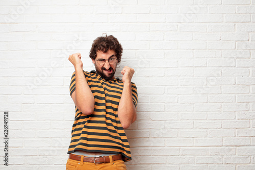 young dumb man with an angry, aggressive and menacing pose, ready for the fight, showing fists furiously and belligerently. photo