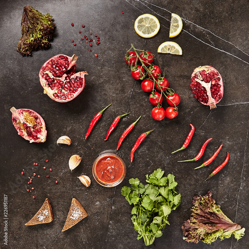Natural Black Marble Background with Spices, Greens and Pomegranate