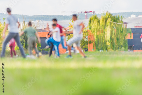 Blurred young children football players running in park