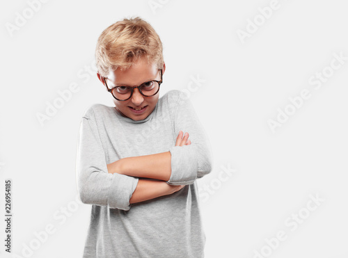 young blonde handsome boy looking angry, unhappy and frustrated, gesturing furiously, with arms crossed, feeling upset and annoyed. photo