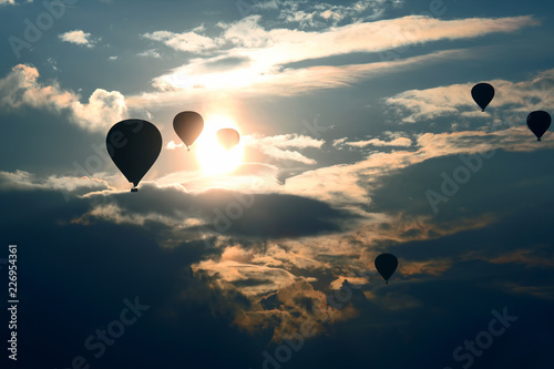 Many passenger balloons fly against the background of dawn in the clouds