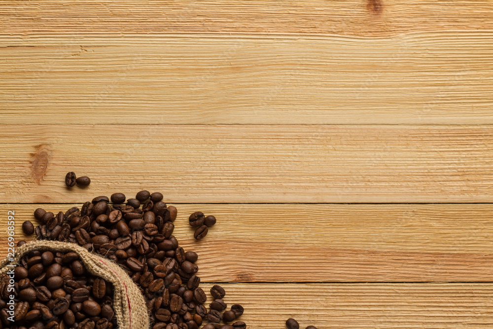 Sack of coffee beans on wooden background Sack of coffee beans on wooden background